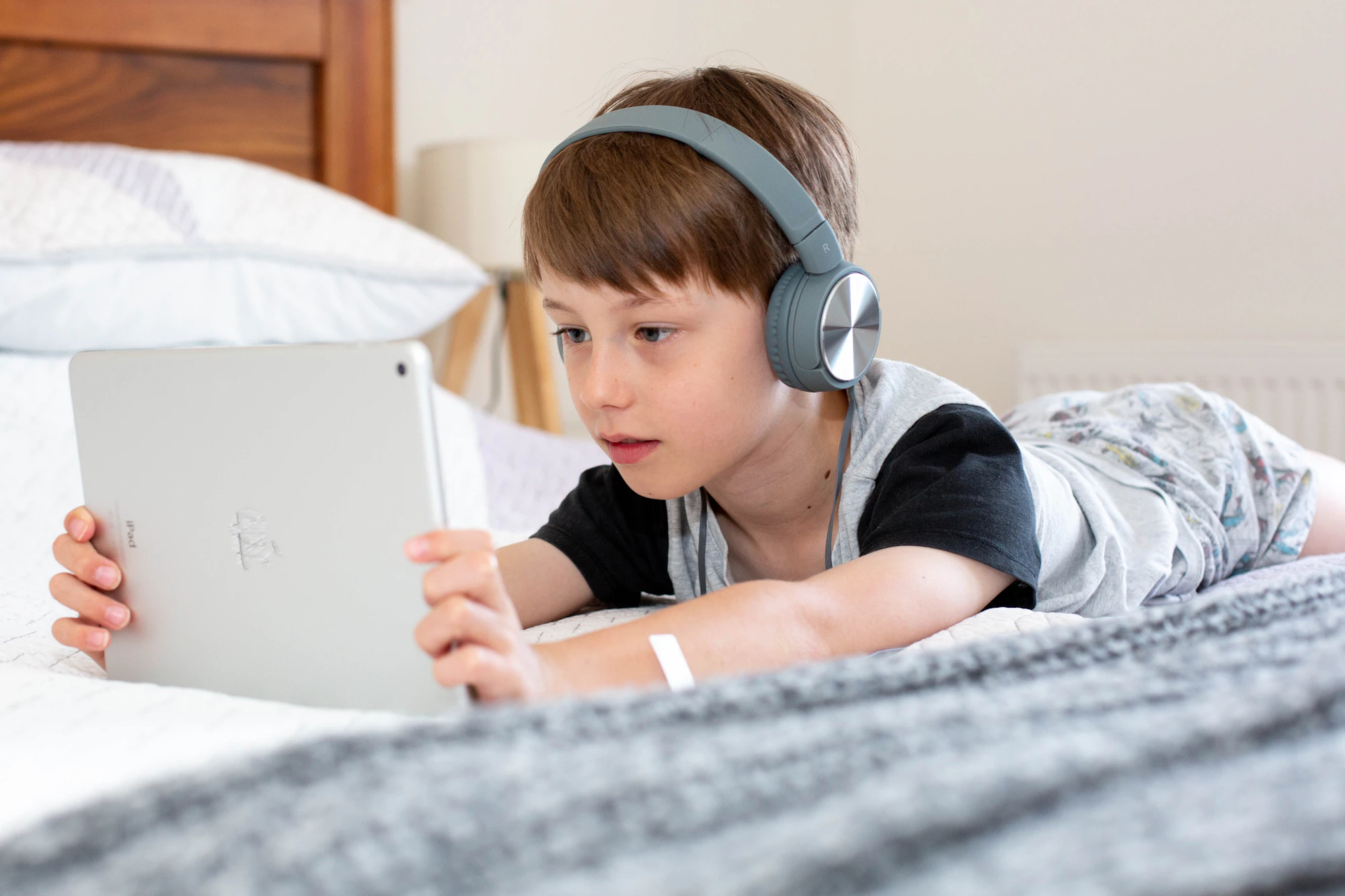 Kid with headphones learning on tablet